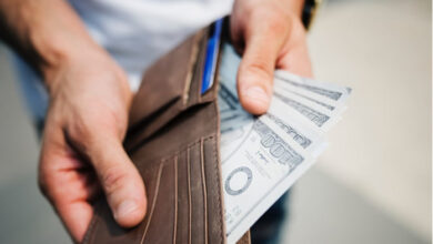 homme montrant son portefeuille rempli d'argent grace aux meilleures facons de gagner de l'argent à domicile ou sur internet